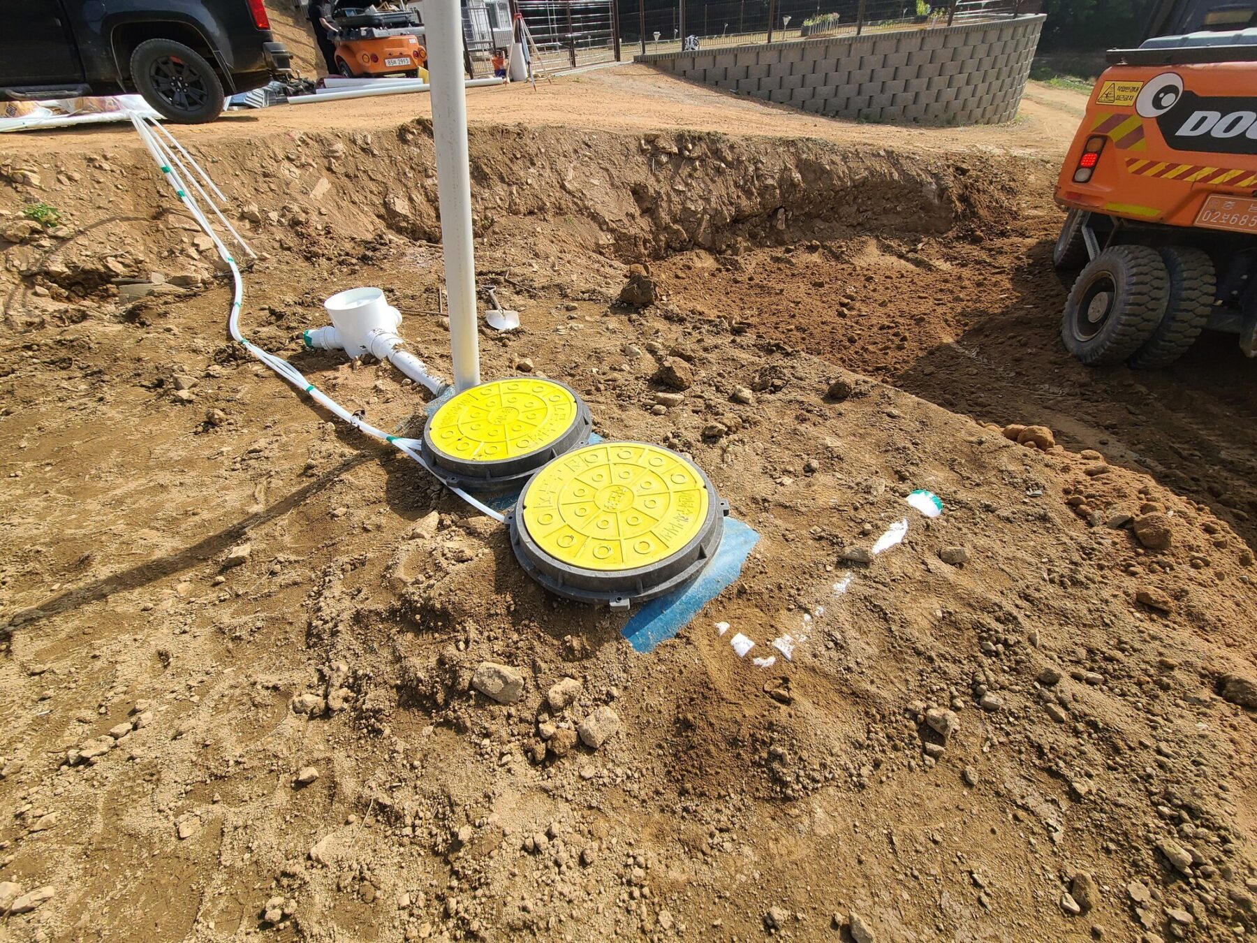 정화조 점검구와 주변 PVC 배관 배치