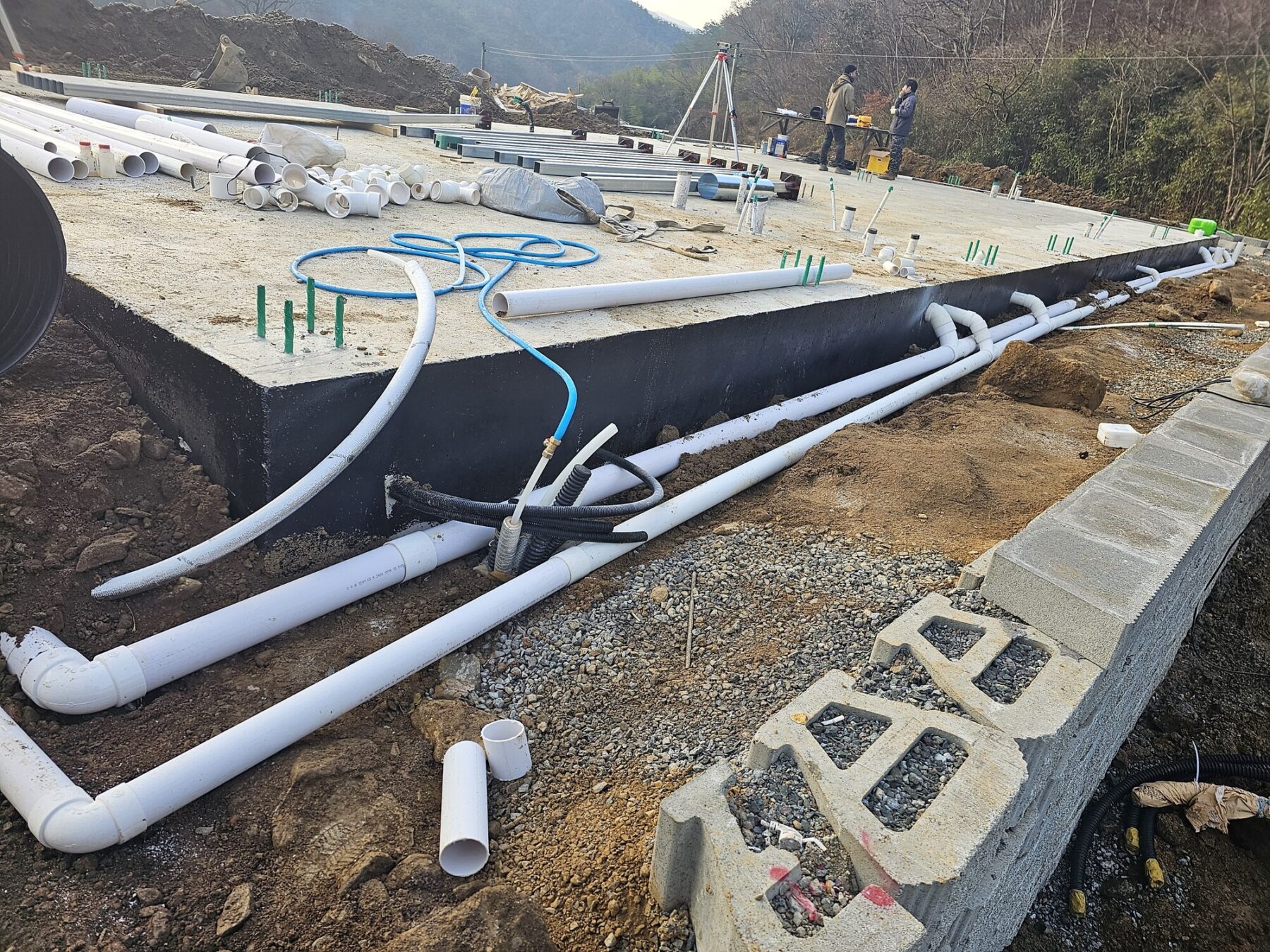 전원주택 기초 외곽을 따라 연결된 여러 PVC 배관