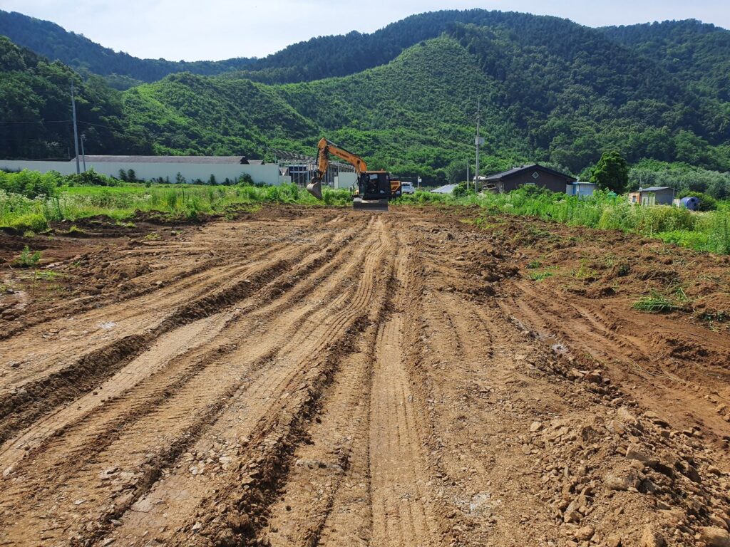 전원주택 예정 부지에서 굴삭기로 기존 지반을 정리하는 실제 현장